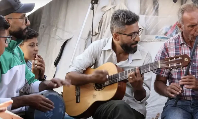 বোমার শব্দগুলোকে গিটারের সাহায্যে গানে পরিনত করছেন গাজার সংগীত শিক্ষক